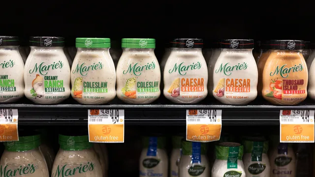 Multiple varieties of Marie’s salad dressing are lined up on a store shelf above price labels and “gluten free” shelf tags. Why gluten-free claims on a specialty food label carry a real number